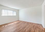 Thumbnail 33 of 48 - the spacious living room with wood flooring and a window