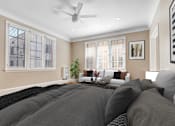 Thumbnail 4 of 8 - a bedroom with a large bed and a couch and a ceiling fan