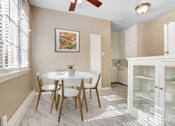 Thumbnail 7 of 8 - a dining room with a white table and chairs