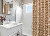 Thumbnail 4 of 17 - Bathroom with single vanity, tub and shower combo with white wall tiles