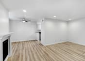 Thumbnail 3 of 18 - an empty living room with white walls and wood flooring