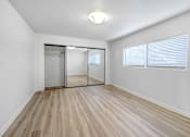 Thumbnail 6 of 18 - an empty living room with a mirrored closet and a window