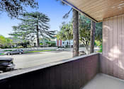 Thumbnail 5 of 18 - a balcony with a view of a street and trees