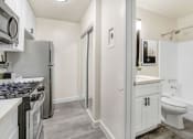 Thumbnail 21 of 83 - a renovated kitchen with white cabinets and a stainless steel refrigerator