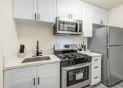 Thumbnail 18 of 83 - an apartment kitchen with stainless steel appliances and white cabinets