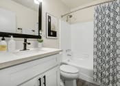Thumbnail 22 of 83 - a white bathroom with a black and white shower curtain