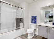 Thumbnail 25 of 42 - Bathroom of a studio apartment with hot tub and shower combo, single vanity, wood style flooring