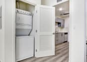Thumbnail 24 of 42 - In-home Washer and Dryer, wood style floors throughout, kitchen on the right
