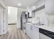 Thumbnail 23 of 42 - Beautiful Kitchen with stainless steel appliances including two-door refrigerator, dishwasher, microwave, electric range, Quartz Countertops, tile backsplash, wood style floors