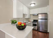 Thumbnail 1 of 22 - Kitchen with stainless steel two-door refrigerator, gas stove over range hood, white cabinets