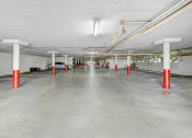 Thumbnail 13 of 15 - an empty parking garage with red and white poles