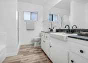 Thumbnail 7 of 9 - a bathroom with white cabinets and a sink and a toilet