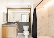 Thumbnail 17 of 31 - a bathroom with a toilet and a sink and a mirror
