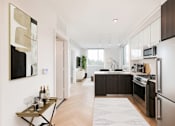 Thumbnail 18 of 31 - a kitchen with stainless steel appliances and a wood floor