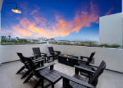 Thumbnail 11 of 26 - a terrace with a table and chairs and a sunset in the sky