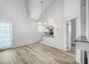 Thumbnail 55 of 62 - the living room and kitchen of an empty home with white walls and wood flooring