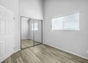 Thumbnail 59 of 62 - an empty bedroom with a mirrored closet door and a window