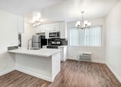Thumbnail 3 of 63 - an open kitchen and living room with a white counter top and a refrigerator