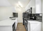 Thumbnail 2 of 63 - a renovated kitchen with white cabinets and black appliances