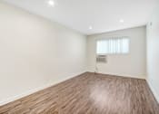Thumbnail 61 of 63 - an empty living room with wood flooring and a window