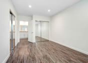 Thumbnail 16 of 63 - a living room with a mirror and a wooden floor