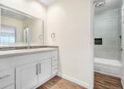 Thumbnail 17 of 63 - a bathroom with white cabinets and a large mirror and a shower