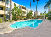 Thumbnail 7 of 19 - a large swimming pool in front of a hotel with palm trees