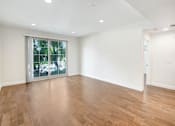 Thumbnail 40 of 88 - an empty living room with a large window and wooden floors