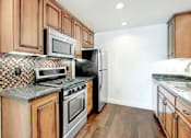 Thumbnail 26 of 88 - a kitchen with wooden cabinets and stainless steel appliances