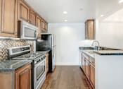 Thumbnail 24 of 88 - a kitchen with wooden cabinets and stainless steel appliances