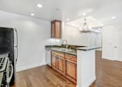 Thumbnail 28 of 88 - a kitchen with a counter top and a refrigerator