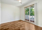 Thumbnail 43 of 88 - an empty living room with a sliding glass door to a balcony