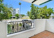 Thumbnail 38 of 88 - a balcony with a car parked on the street next to a wall and a railing
