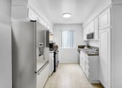 Thumbnail 6 of 14 - a kitchen with stainless steel appliances and white cabinets
