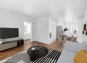 Thumbnail 2 of 14 - a living room with a couch and a table and a tv