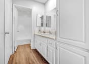 Thumbnail 5 of 14 - a bathroom with white cabinets and a sink and a mirror