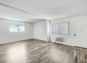 Thumbnail 55 of 66 - the spacious living room of an apartment with wood flooring and white walls