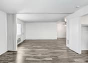 Thumbnail 60 of 66 - an empty living room with a wood floor and white walls