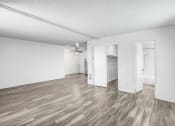 Thumbnail 54 of 66 - an empty living room with white walls and wood flooring