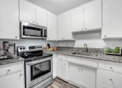 Thumbnail 9 of 66 - a kitchen with white cabinets and stainless steel appliances