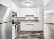 Thumbnail 18 of 66 - an empty kitchen with white cabinets and stainless steel appliances