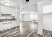 Thumbnail 47 of 66 - an empty living room and kitchen with white cabinets and wood flooring
