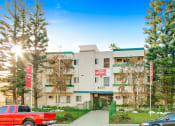 Thumbnail 16 of 17 - a white apartment building with green trim and a red sign that reads 801