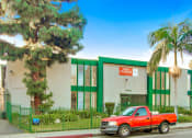 Thumbnail 13 of 17 - a red truck parked in front of a green and white building
