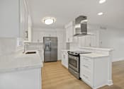 Thumbnail 99 of 208 - A modern kitchen with white cabinets and stainless steel appliances.