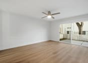 Thumbnail 104 of 208 - A room with a ceiling fan and wooden flooring.