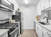 Thumbnail 1 of 91 - a white kitchen with stainless steel appliances and white cabinets
