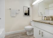 Thumbnail 6 of 61 - a bathroom with a toilet and a sink and a mirror
