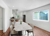 Thumbnail 2 of 57 - a dining area with a table and chairs and a kitchen in the background