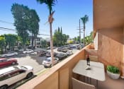 Thumbnail 7 of 57 - a balcony with a table and a view of a parking lot